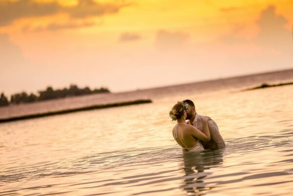 A wedding couple in the water at sunset