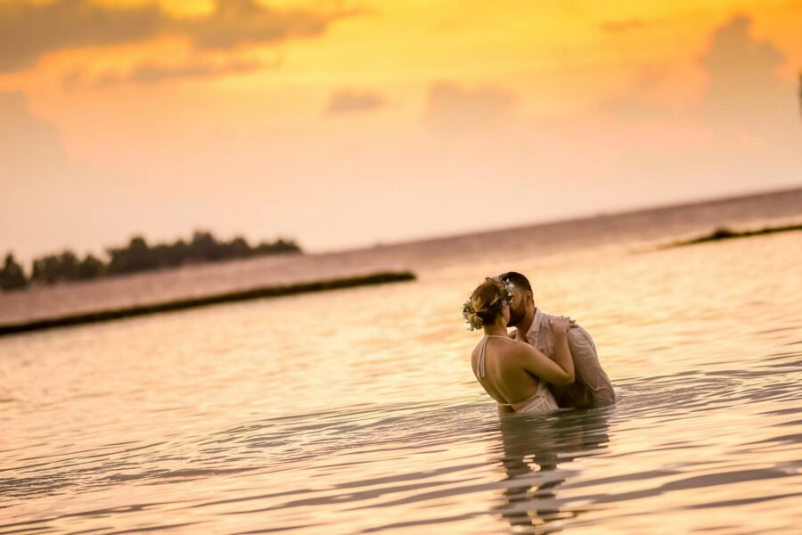 A wedding couple in the water at sunset